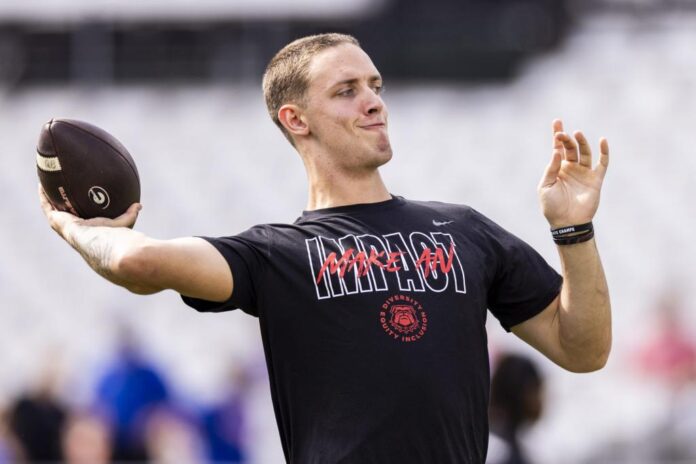 Carson Beck 15 of the Georgia Bulldogs warms up before the start of a game against the Florida Gators e1699050050303